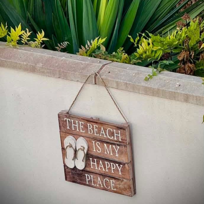 The Beach Is My Happy Place Wooden Hanging Sign in the Garden